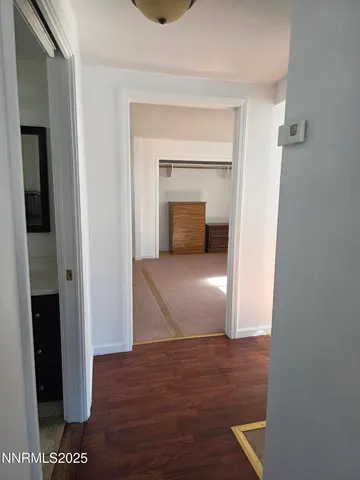 a view of a hallway with wooden floor and closet