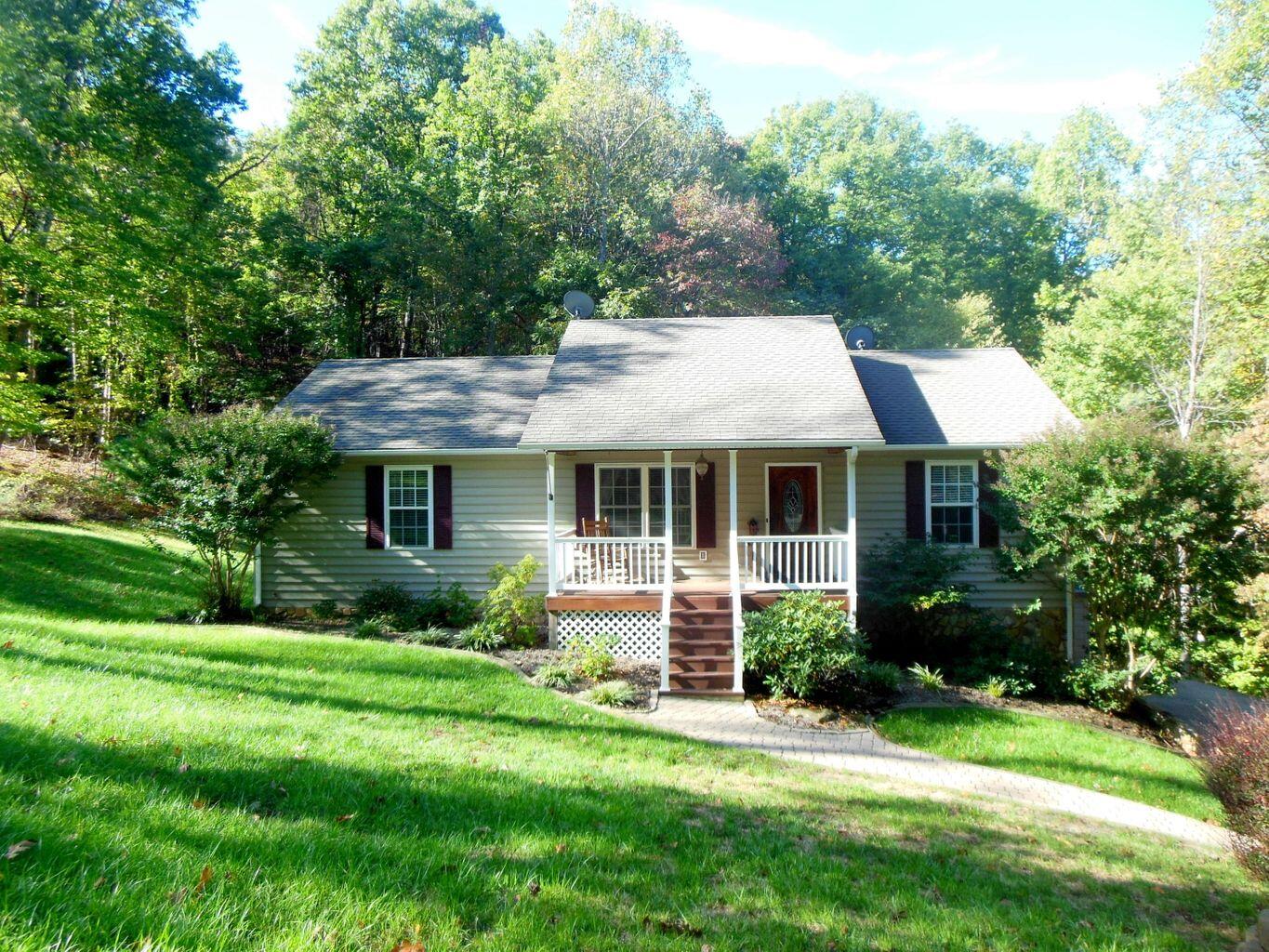 a view of a house with a big yard plants and large trees