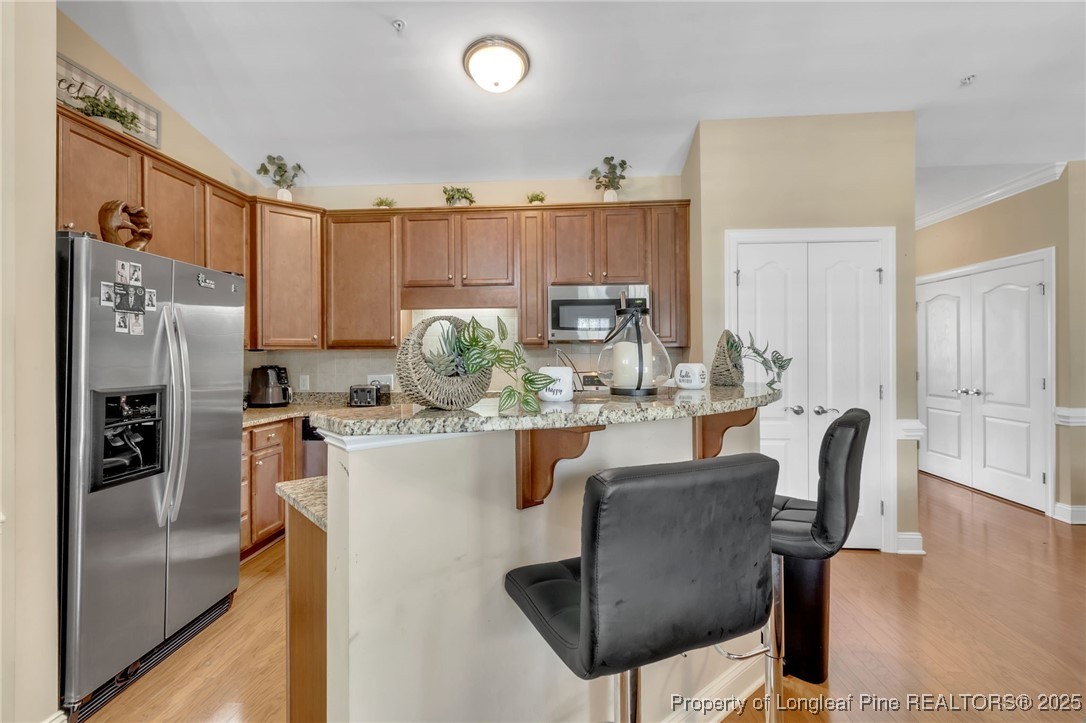 124 Gallery Drive, Unit 302 Spring Lake, NC 28390 - Photo 11 of 33 a kitchen with stainless steel appliances granite countertop a dining table chairs refrigerator and sink