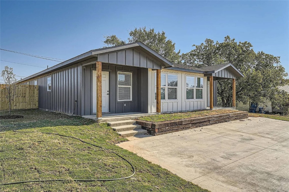 View of front facade featuring board and batten siding and covered porch
