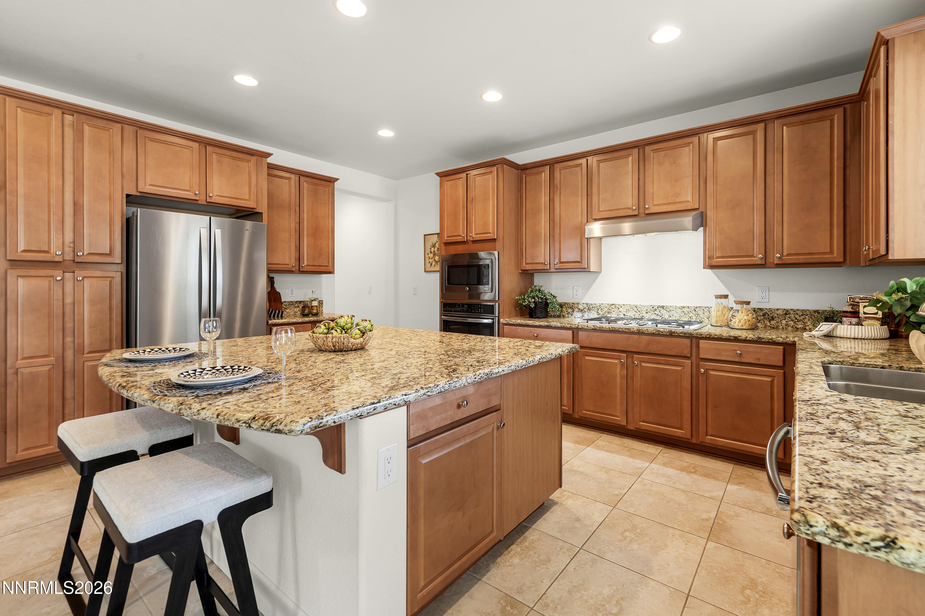 10150 Barrel Racer Drive Reno, NV 89521 - Photo 15 of 64 a kitchen with stainless steel appliances granite countertop a kitchen island hardwood floor sink stove and granite counter top