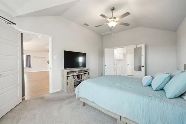 a bedroom with a large bed and a flat screen tv