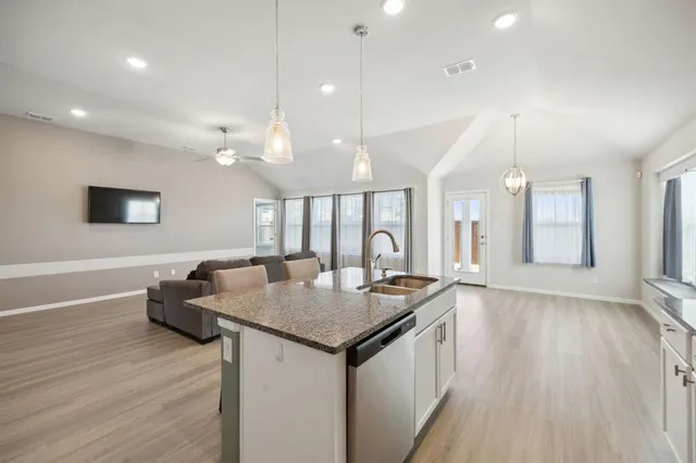 a kitchen with a sink cabinets and wooden floor