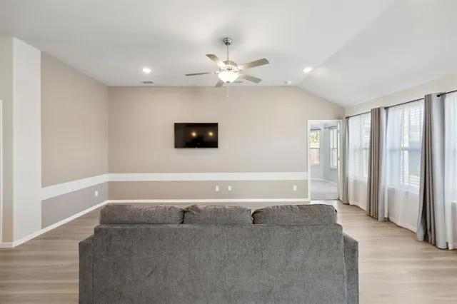 a living room with furniture and a ceiling fan