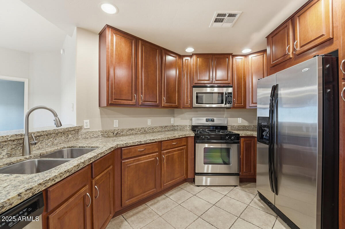 5450 East Deer Valley Drive, Unit 2024 Phoenix, AZ 85054 - Photo 2 of 50 a kitchen with stainless steel appliances granite countertop a stove sink and refrigerator