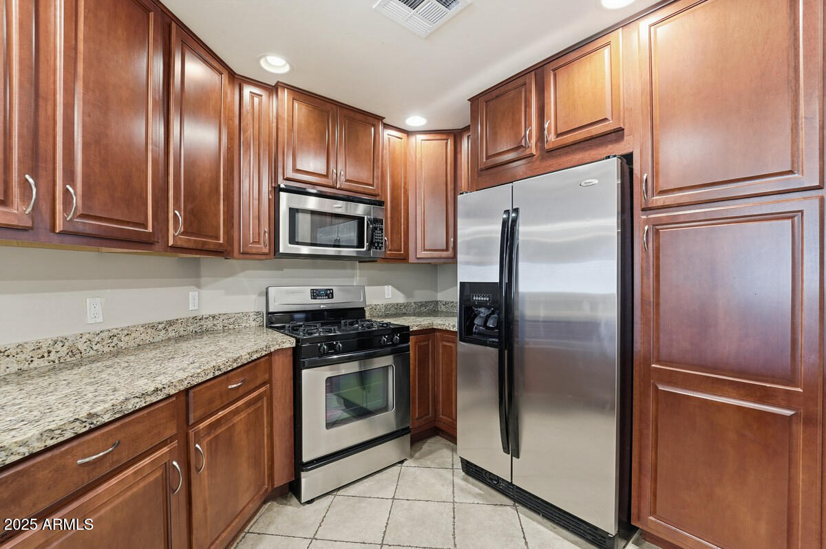 5450 East Deer Valley Drive, Unit 2024 Phoenix, AZ 85054 - Photo 3 of 50 a kitchen with granite countertop stainless steel appliances a refrigerator a stove top oven and granite counter tops