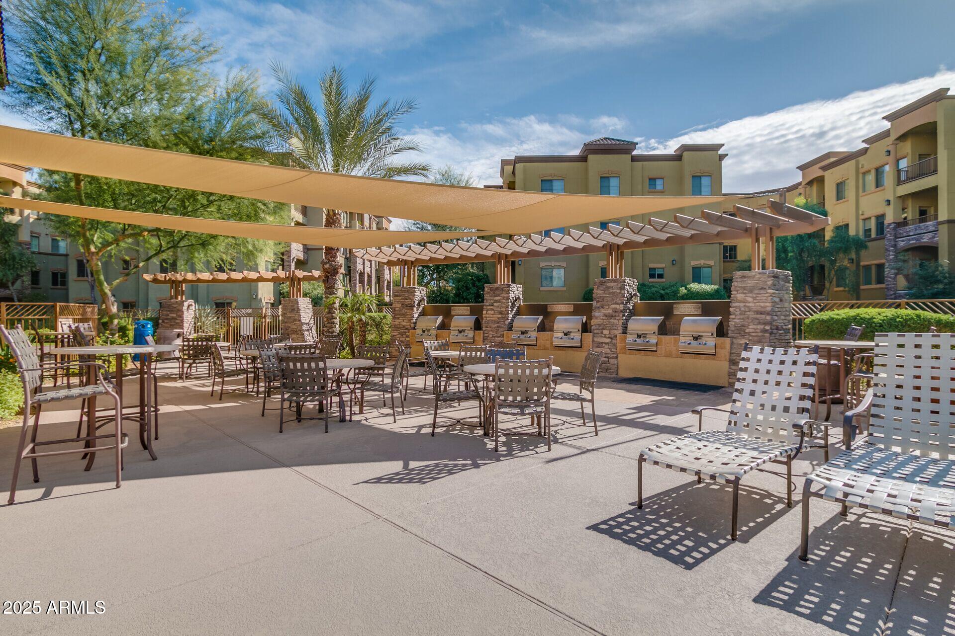 5450 East Deer Valley Drive, Unit 2024 Phoenix, AZ 85054 - Photo 42 of 50 a view of a patio with a table and chairs and potted plants