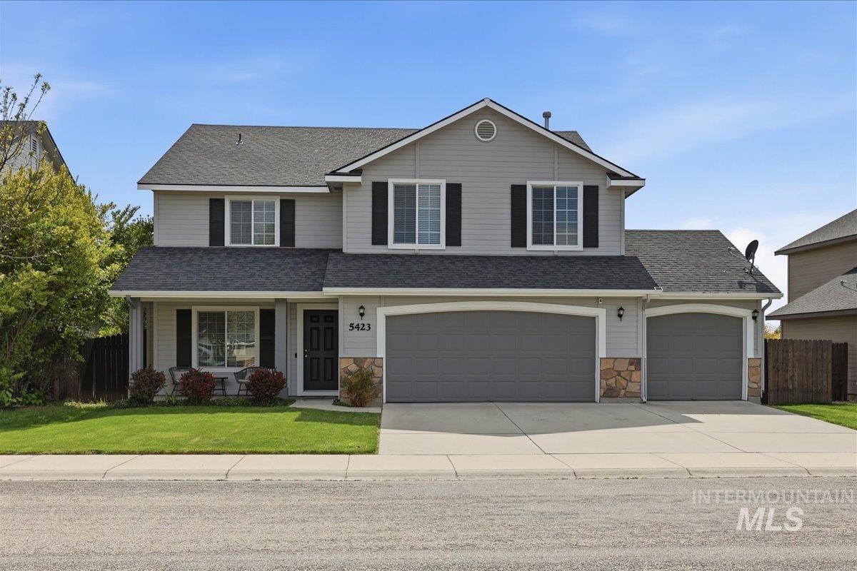 5423 North Isla Avenue Meridian, ID 83646 - Photo 1 of 1 Two-story residence featuring light gray siding, dark gray roofing, and a stone veneer foundation accent