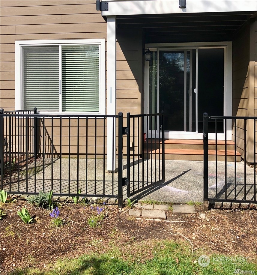 820 Cady Road, Unit B103 Everett, WA 98203 - Photo 15 of 16 a view of a backyard with a large window and wooden fence