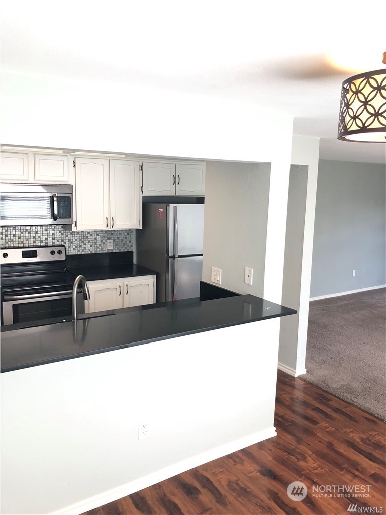820 Cady Road, Unit B103 Everett, WA 98203 - Photo 7 of 16 a living room with stainless steel appliances kitchen island granite countertop a refrigerator and a stove