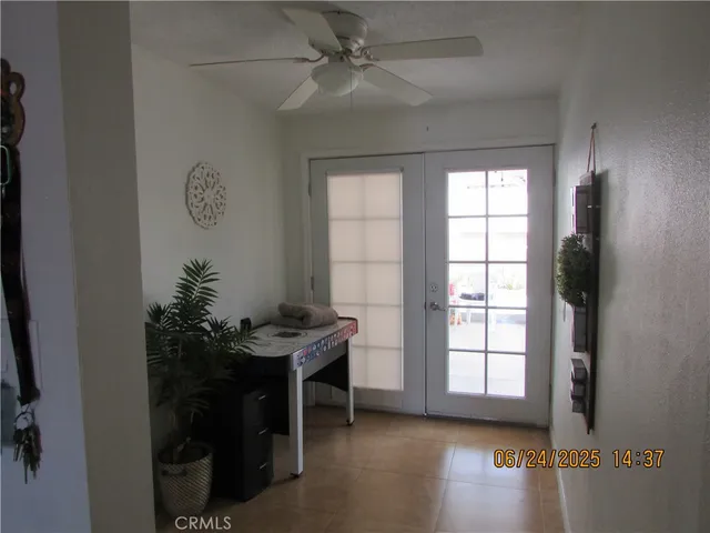 an empty room with windows and fan