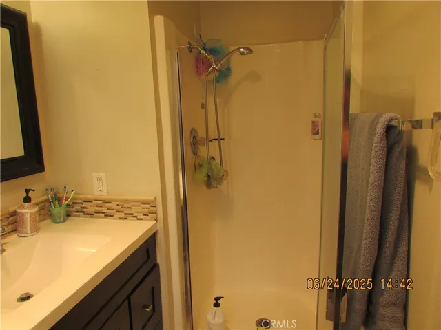 a bathroom with a granite countertop shower mirror and a sink