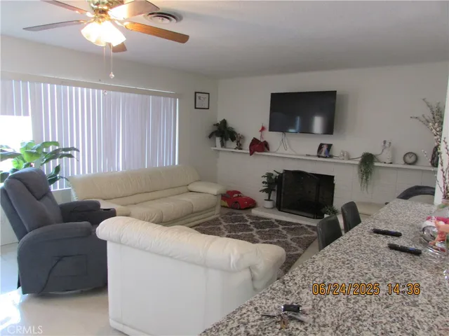 a living room with furniture a flat screen tv and a fireplace