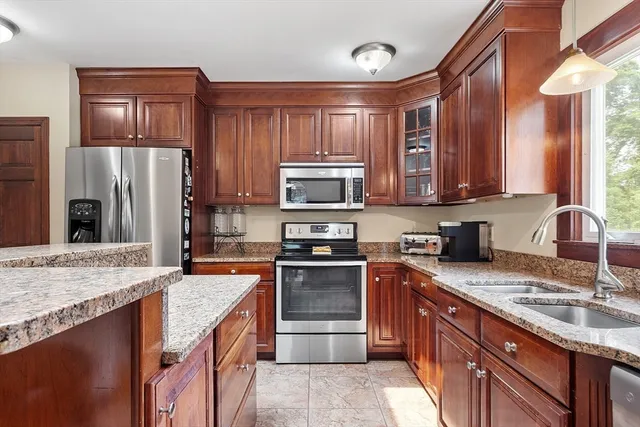 a kitchen with stainless steel appliances granite countertop a stove top oven a sink and dishwasher