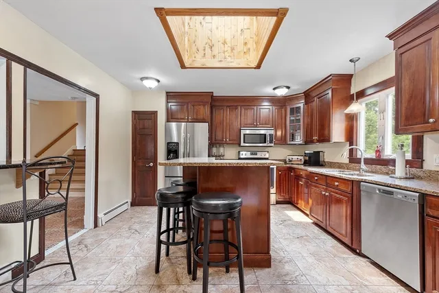 a kitchen with stainless steel appliances granite countertop a stove a sink and a refrigerator