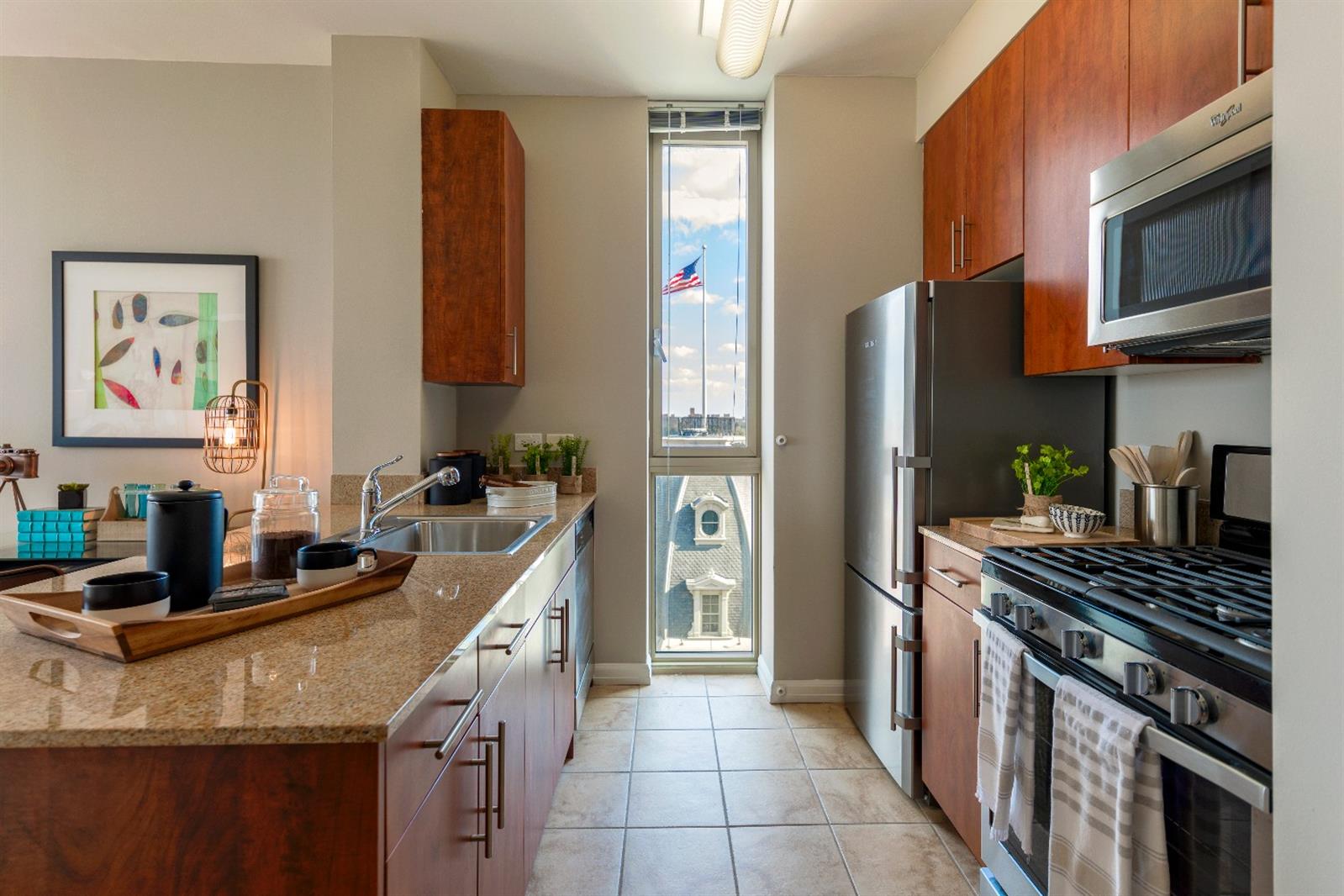 a kitchen with stainless steel appliances granite countertop a stove refrigerator sink and microwave