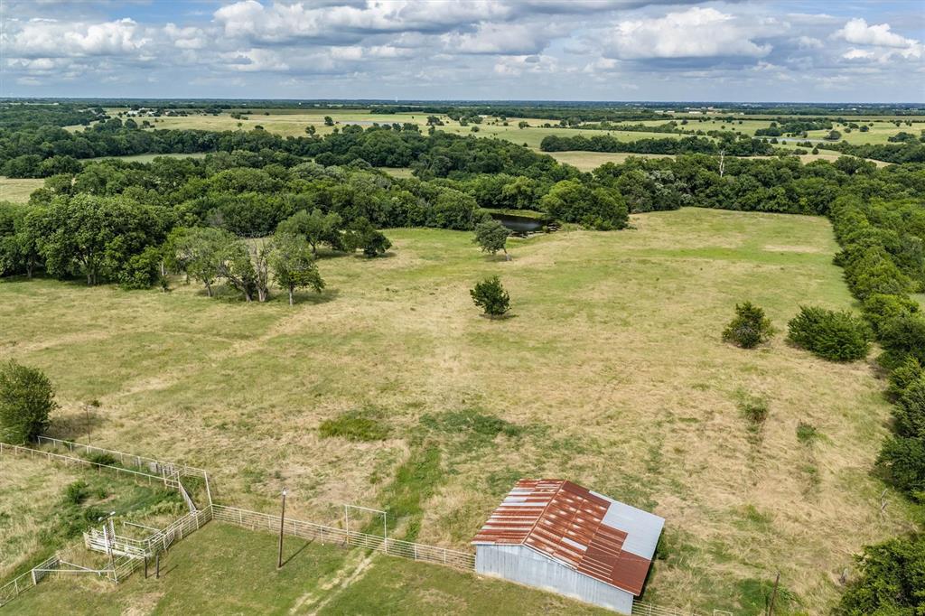 13132 Highway 78 Blue Ridge, TX 75424 - Photo 30 of 35 Expansive rural landscape featuring a barn with a corrugated metal roof, fenced pasture areas, and mature trees