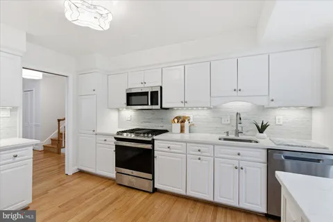 a living room with furniture kitchen view and large windows