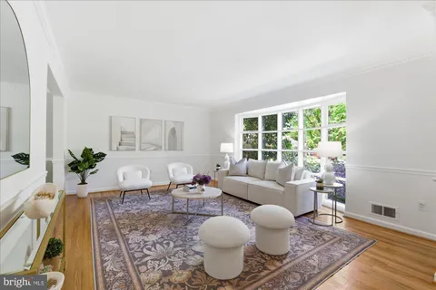 a living room with furniture a wooden floor and a chandelier