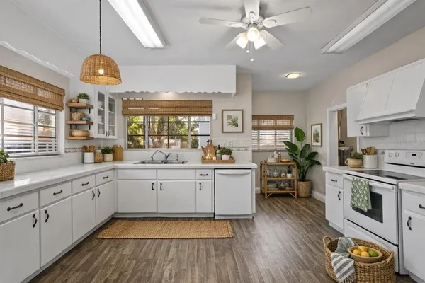 a large kitchen with stainless steel appliances a stove a sink dishwasher and a fireplace with wooden floor