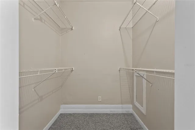 a view of walk in closet with clothes
