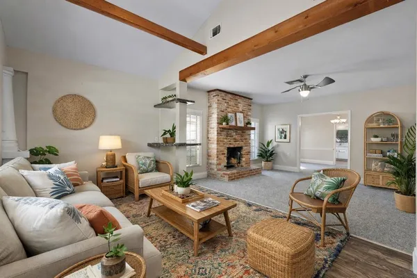 a living room with furniture a fireplace and a large window