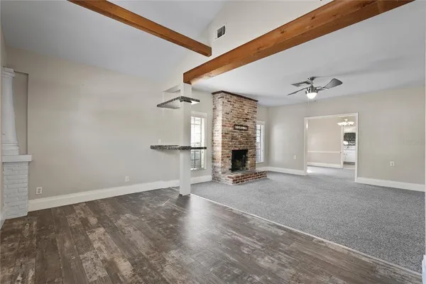 an empty room with windows and ceiling fan