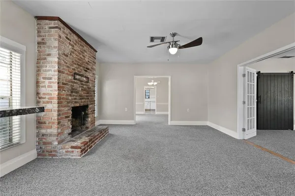 a view of a livingroom with a fireplace and window