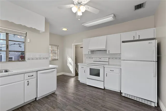 a kitchen with white cabinets and white appliances