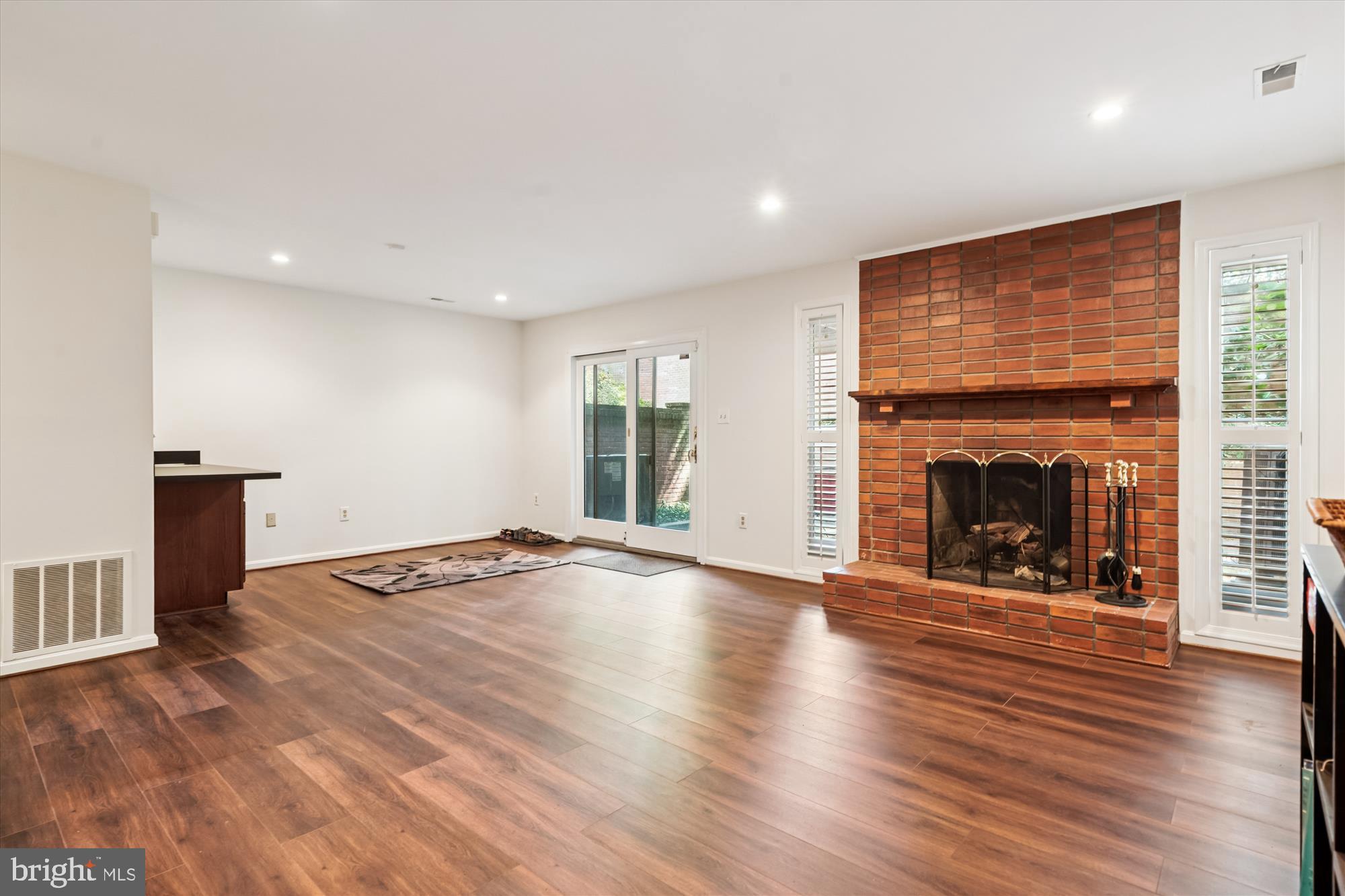3922 North Glebe Road Arlington, VA 22207 - Photo 38 of 46 an empty room with wooden floor a fireplace and windows