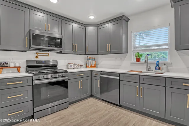 a kitchen with cabinets stainless steel appliances and a sink