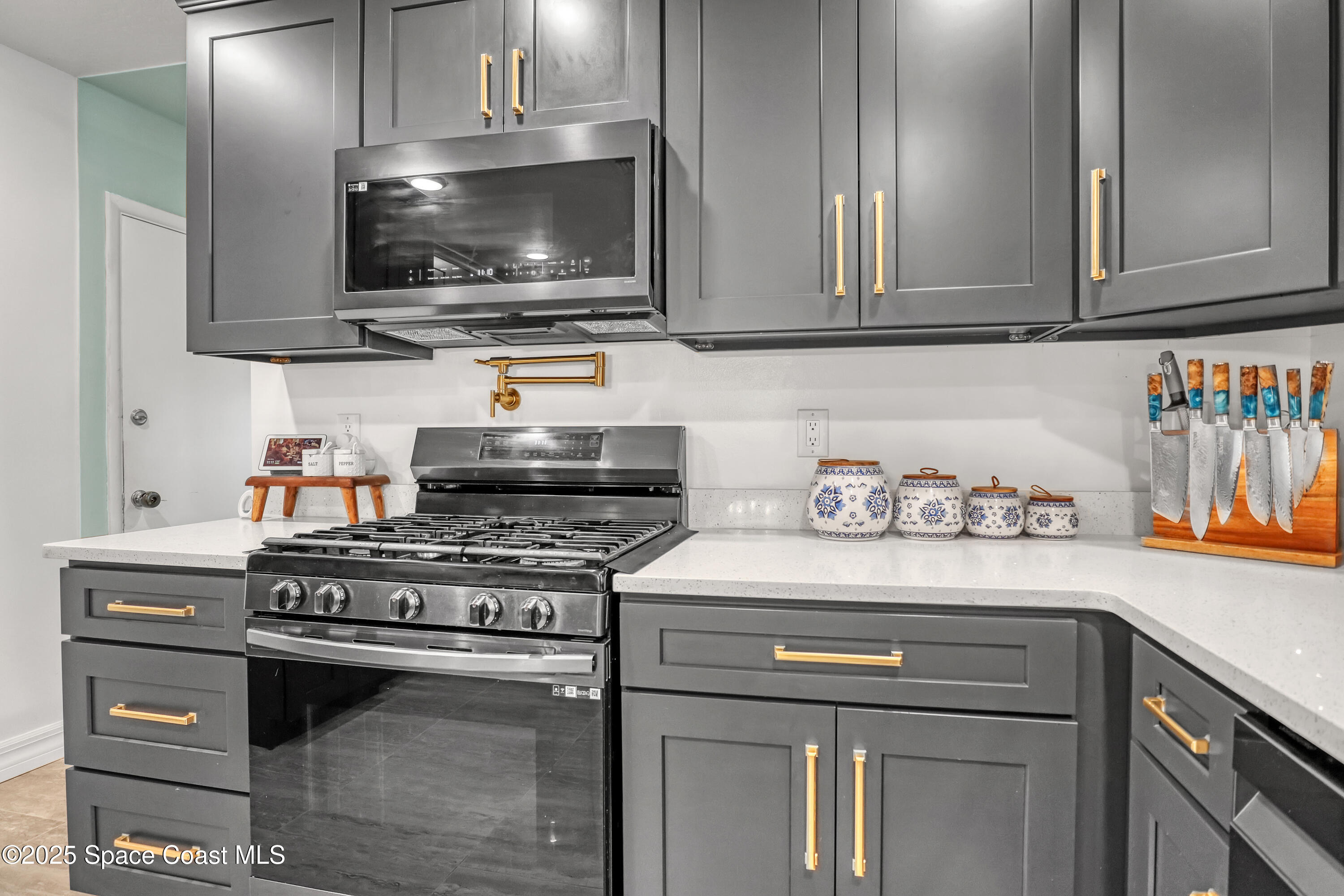2307 Country Club Road Melbourne, FL 32901 - Photo 12 of 50 a kitchen with stainless steel appliances granite countertop a stove and a microwave