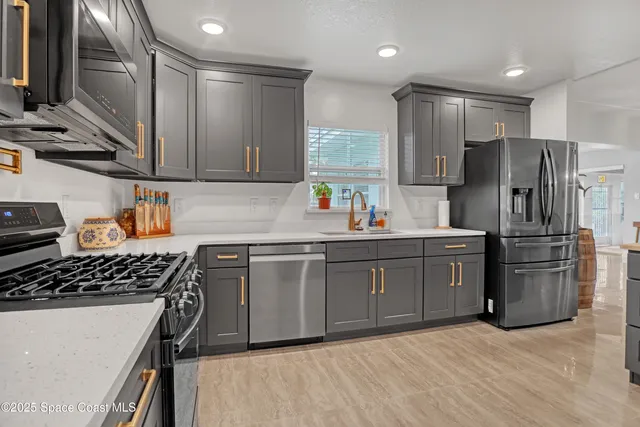 a kitchen with stainless steel appliances granite countertop a sink stove and refrigerator