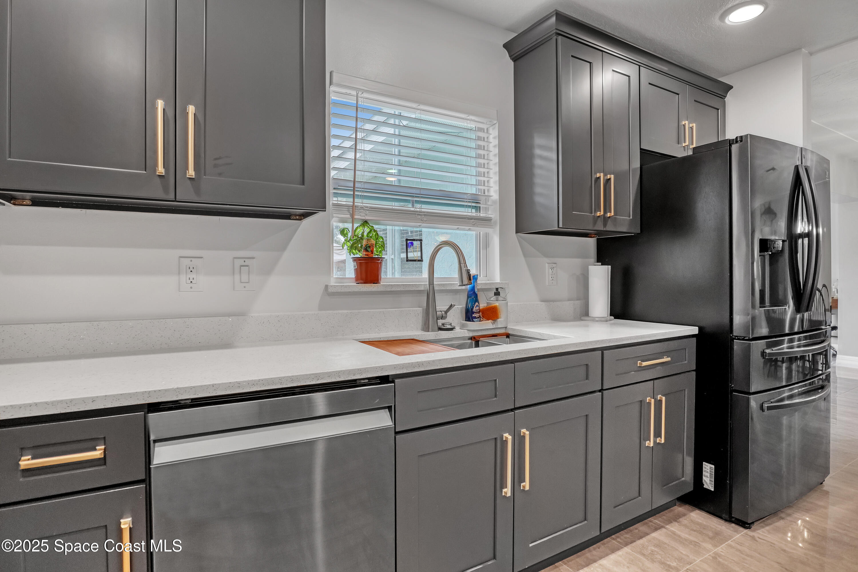 2307 Country Club Road Melbourne, FL 32901 - Photo 14 of 50 a kitchen with stainless steel appliances a sink cabinets and a window