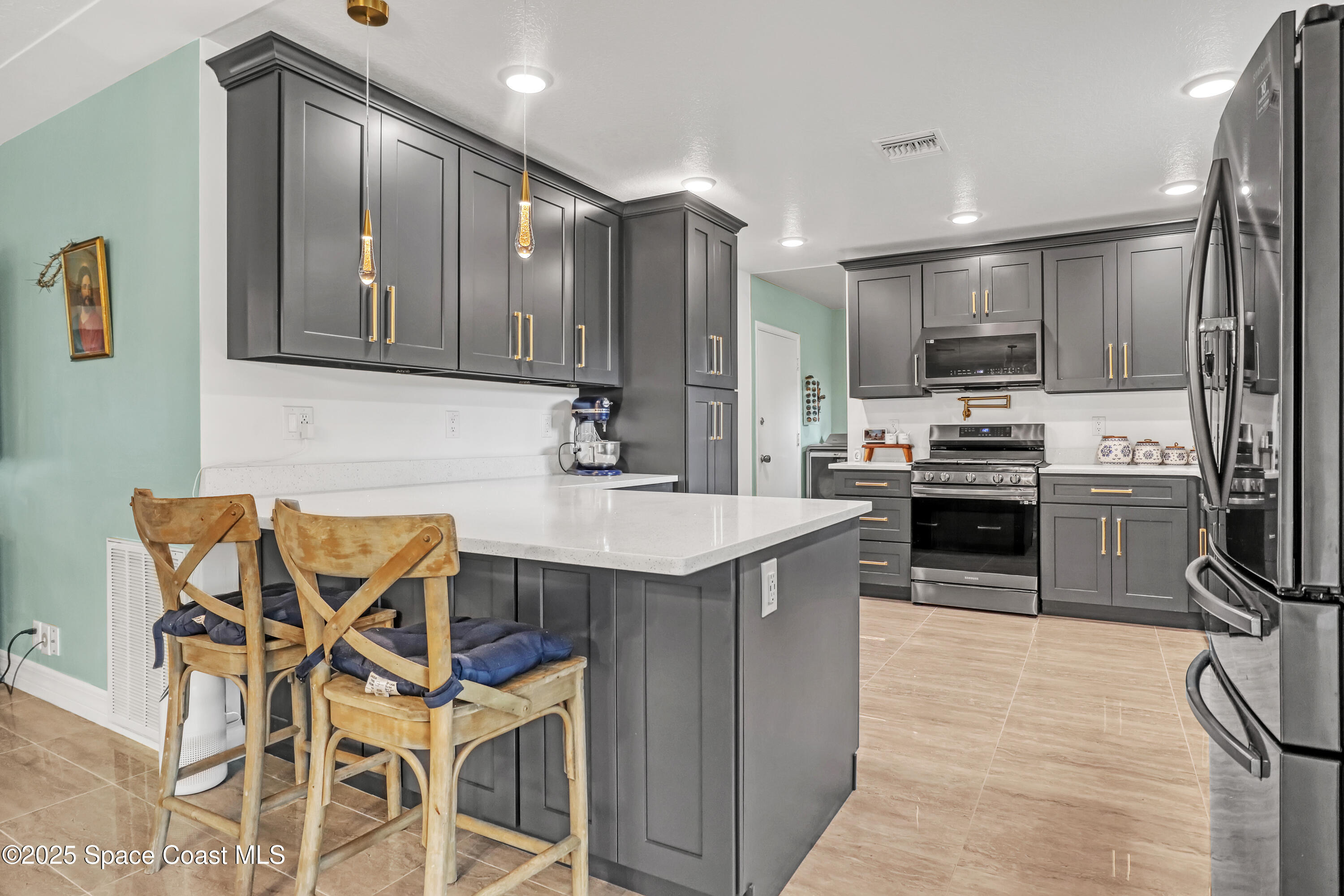 2307 Country Club Road Melbourne, FL 32901 - Photo 9 of 50 a kitchen with stainless steel appliances kitchen island granite countertop a sink and cabinets