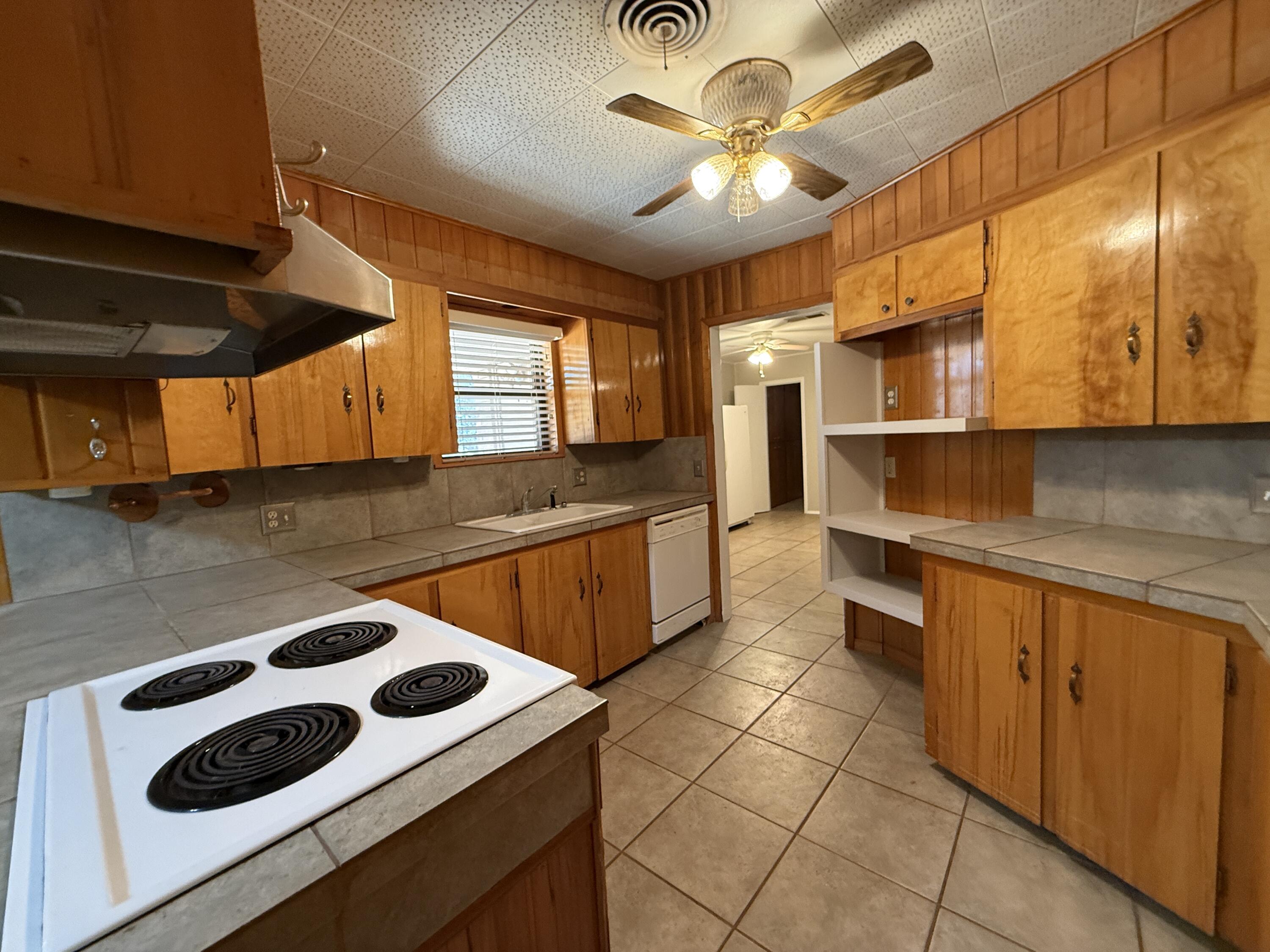 3391 Fisher Road Levelland, TX 79336 - Photo 16 of 47 a kitchen with a sink a stove and cabinets