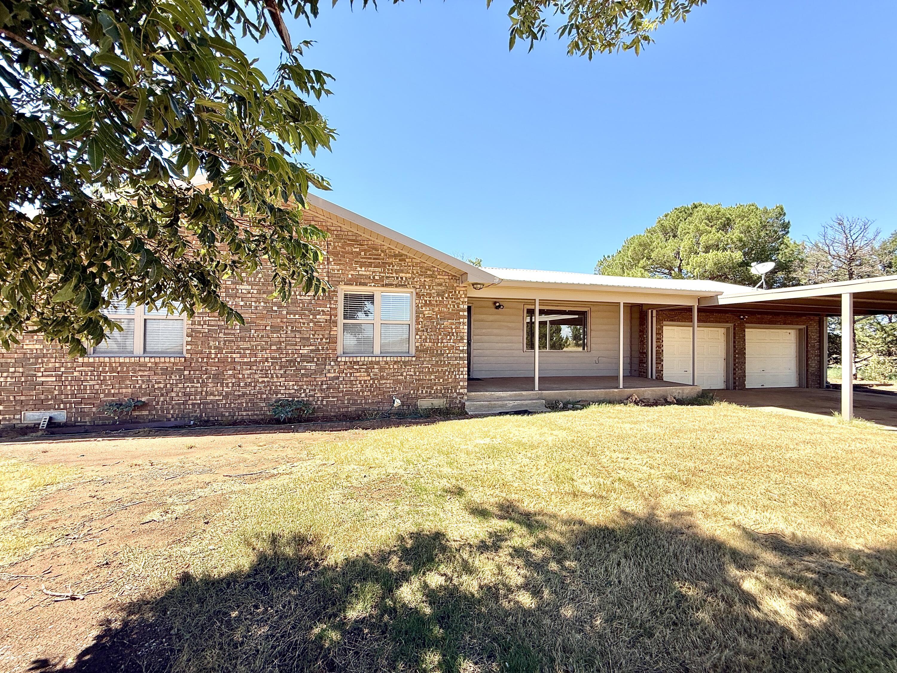 3391 Fisher Road Levelland, TX 79336 - Photo 2 of 47 a front view of a house with a yard and garage
