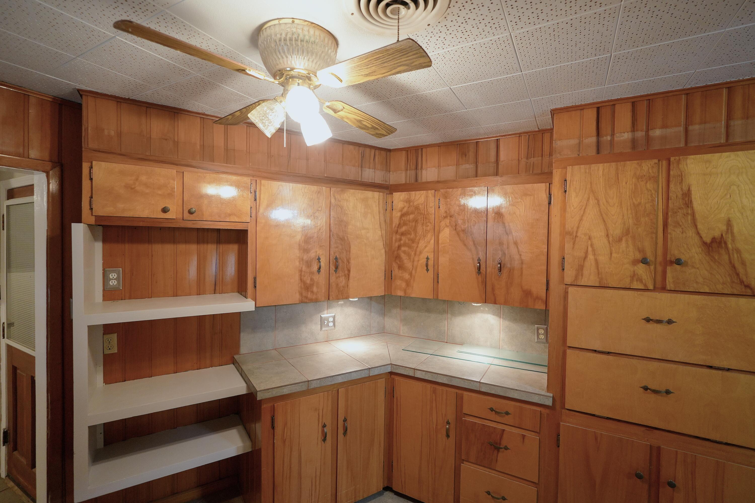 3391 Fisher Road Levelland, TX 79336 - Photo 21 of 47 a kitchen with kitchen island a chandelier and wooden cabinets