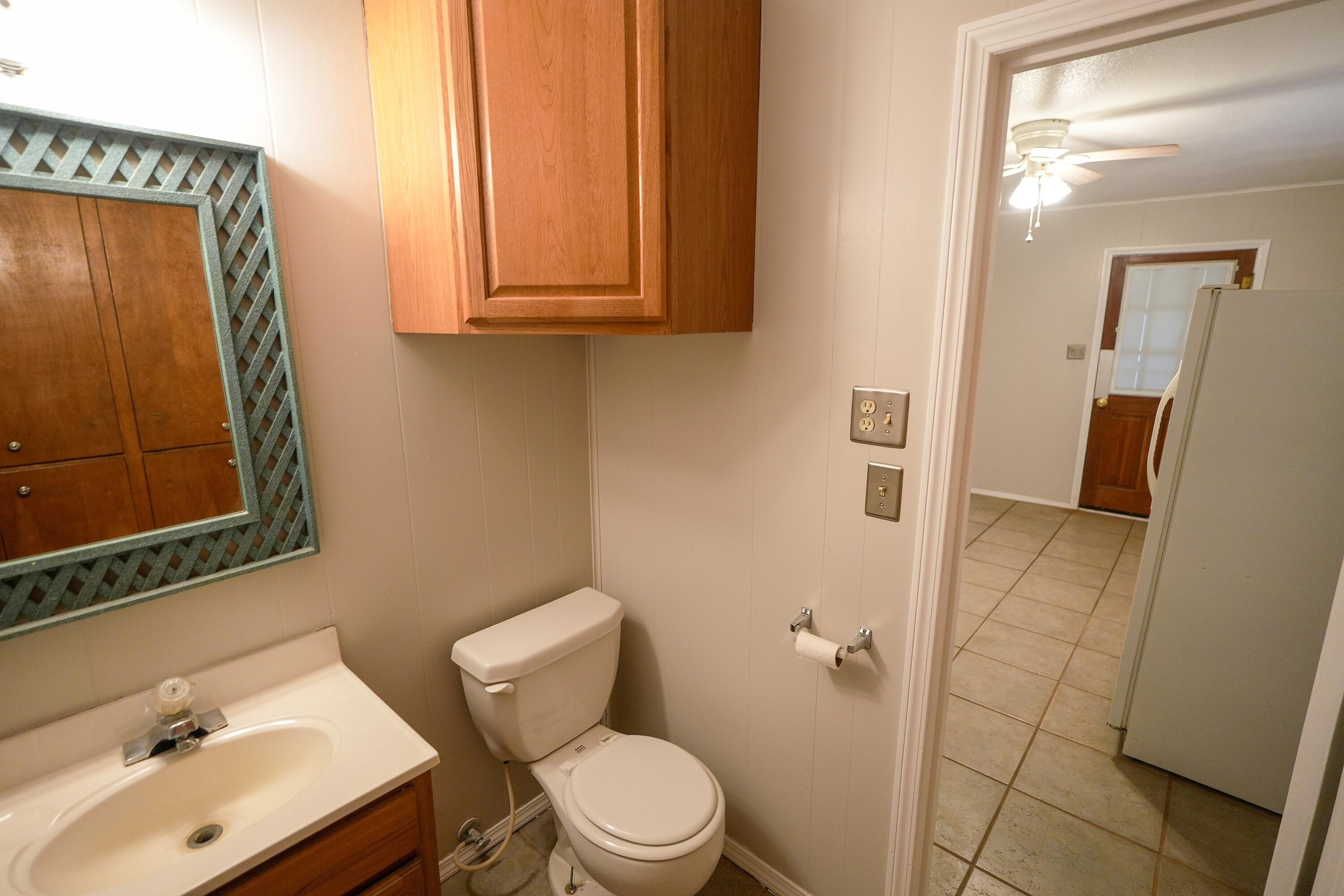 3391 Fisher Road Levelland, TX 79336 - Photo 23 of 47 a bathroom with a sink a toilet and shower curtain