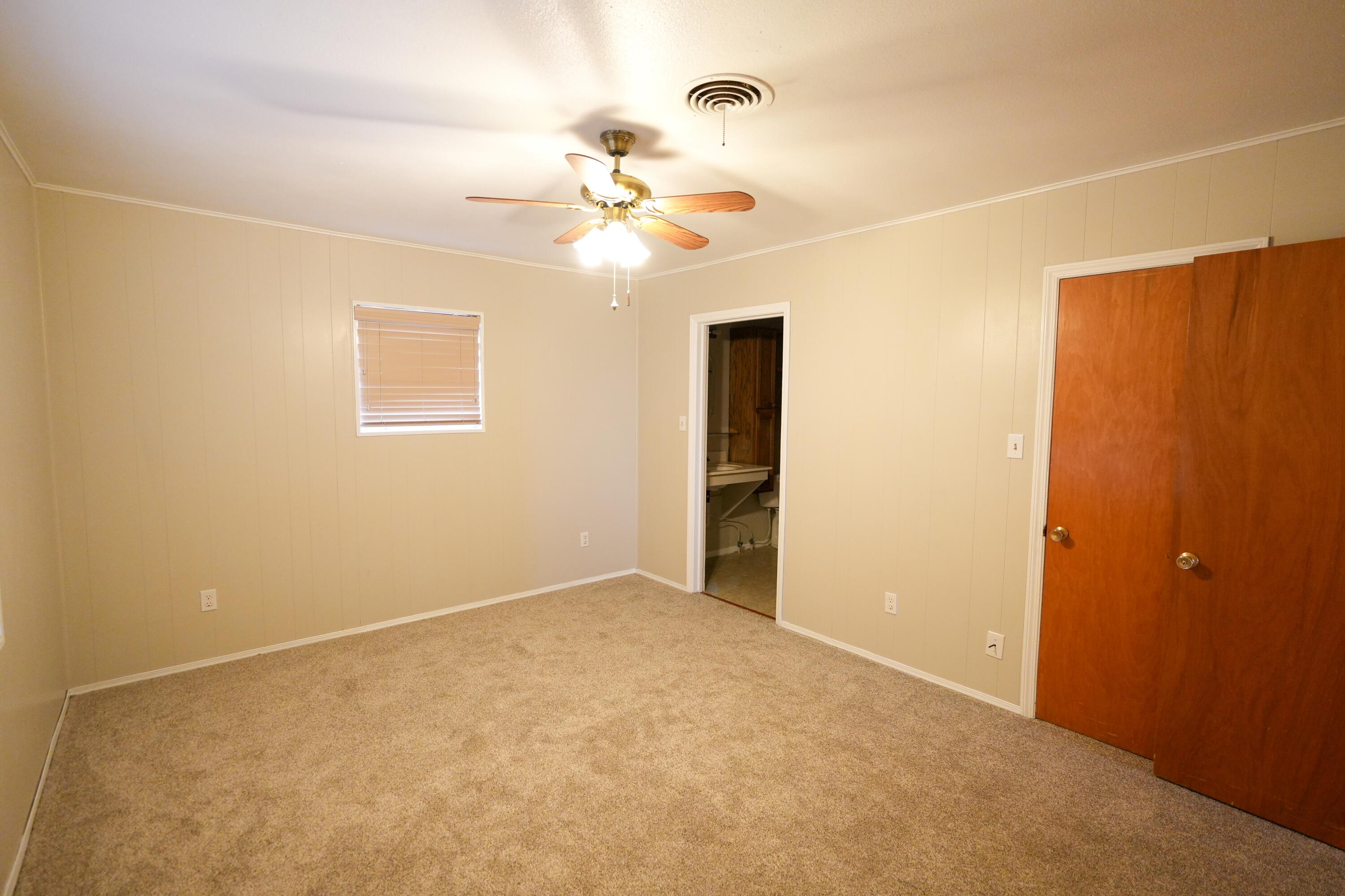 3391 Fisher Road Levelland, TX 79336 - Photo 26 of 47 an empty room with a chandelier fan and a window