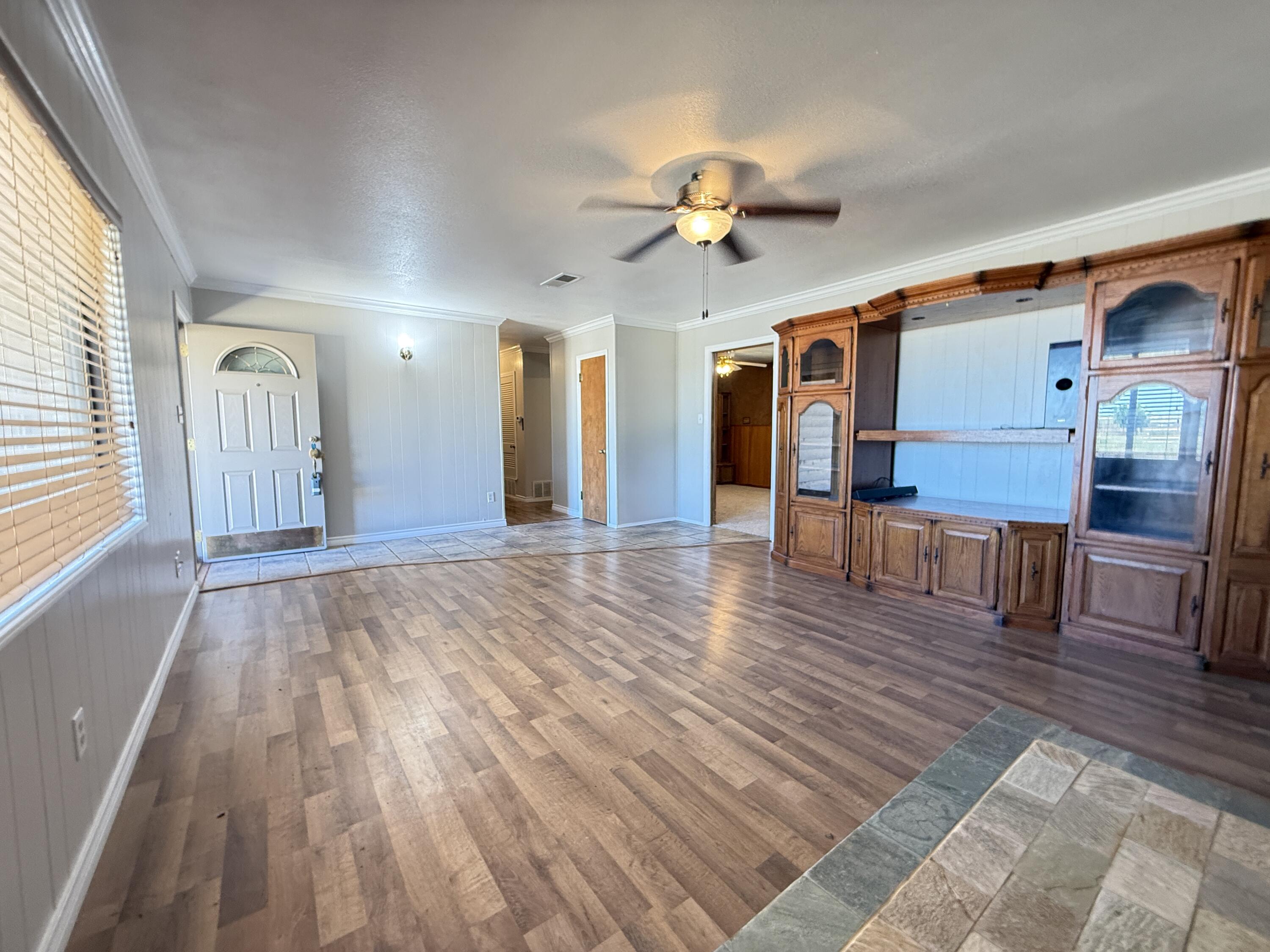 3391 Fisher Road Levelland, TX 79336 - Photo 5 of 47 a view of a livingroom with furniture a ceiling fan and wooden floor