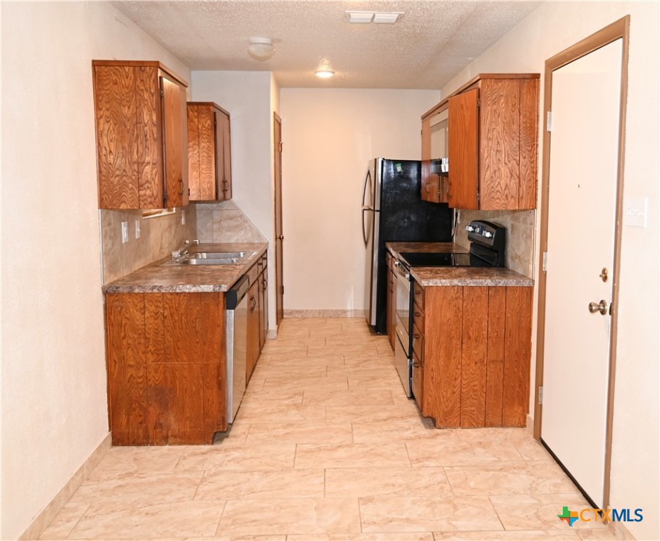 928 Randa Street Copperas Cove, TX 76522 - Photo 5 of 19 a kitchen with stainless steel appliances granite countertop a stove and a refrigerator
