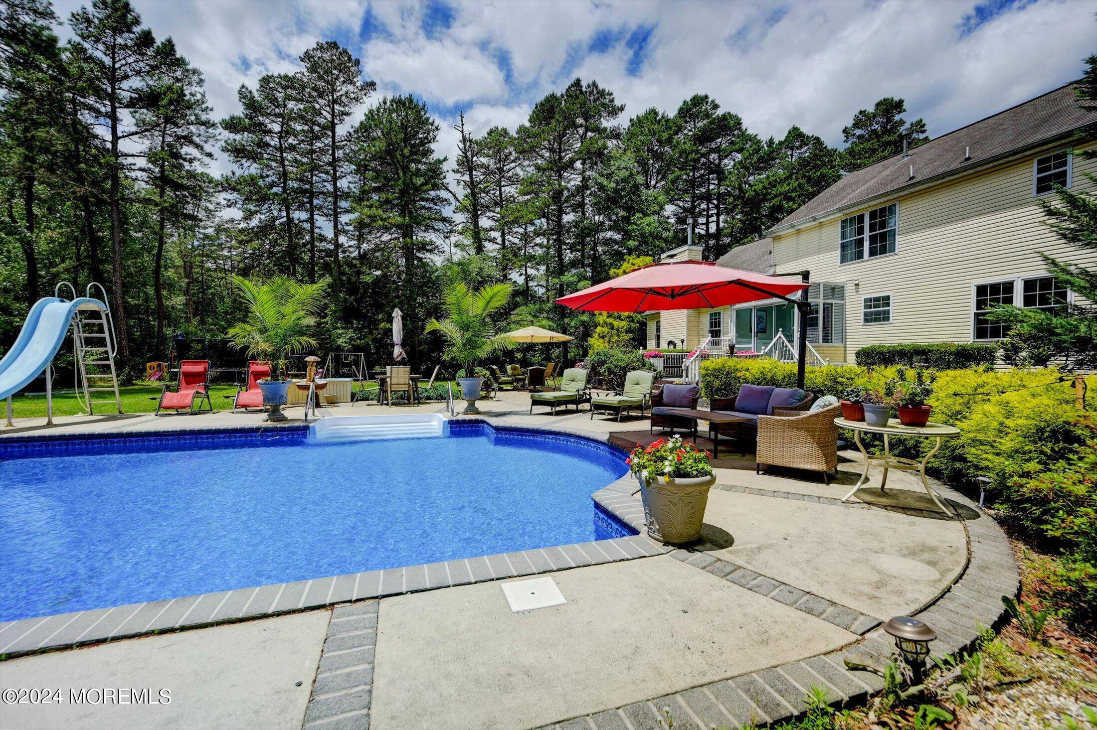 227 East Pleasant Grove Road Jackson, NJ 08527 - Photo 3 of 53 a view of a patio with a table and chairs under an umbrella