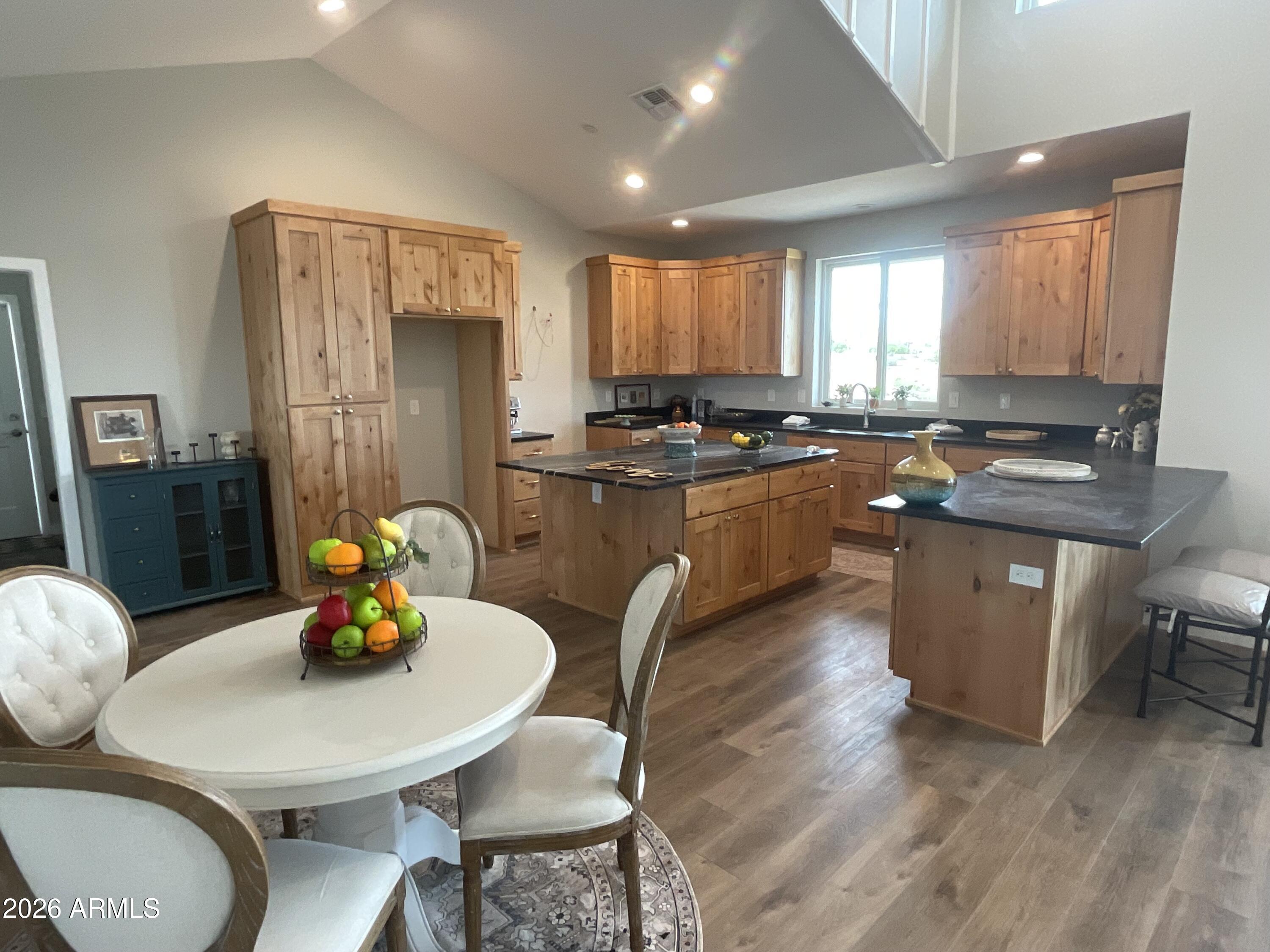 498 Kindra Heights Road Cottonwood, AZ 86326 - Photo 5 of 37 a kitchen with stainless steel appliances granite countertop a stove a refrigerator a kitchen island a table and chairs in it