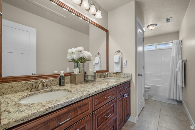 955 Delorean Lane Midvale, UT 84047 - Photo 31 of 47 Double vanity with granite-style countertop, undermount sinks, and wood-finish cabinetry