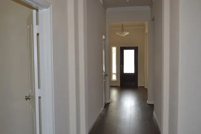 a view of a hallway with wooden floor and a hallway