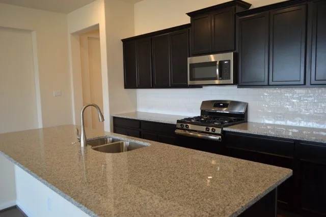 a view of a kitchen island a sink and dishwasher with wooden floor