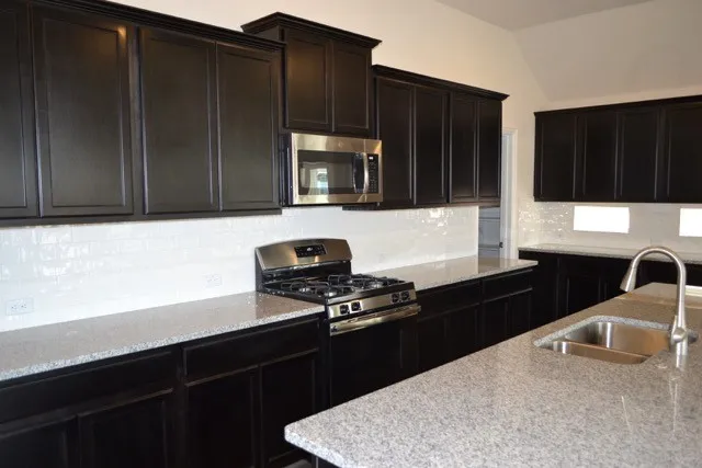 a kitchen with a sink stainless steel appliances and cabinets