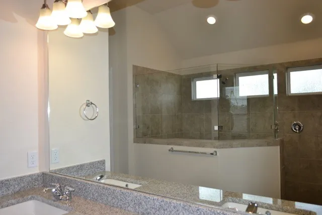 a kitchen with granite countertop a refrigerator and a stove top oven