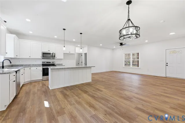 a view of kitchen with granite countertop stainless steel appliances cabinets a sink and a counter top
